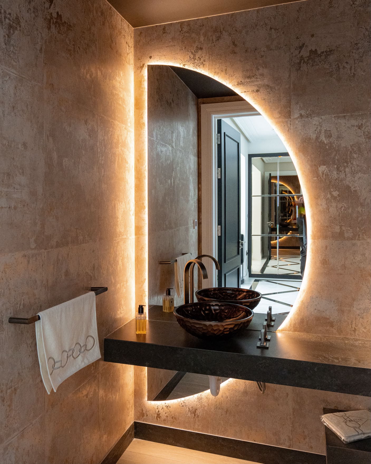 Guest cloakroom with wall-hung stone basin and backlit mirror