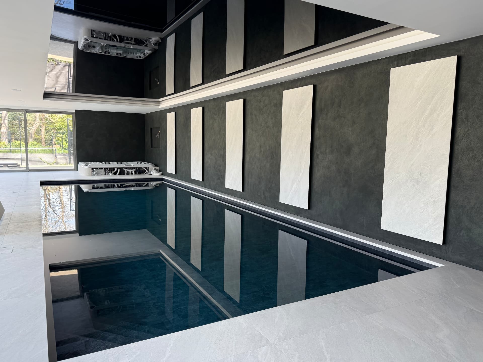 Stone-tiled indoor pool with recessed ceiling cove ventilation