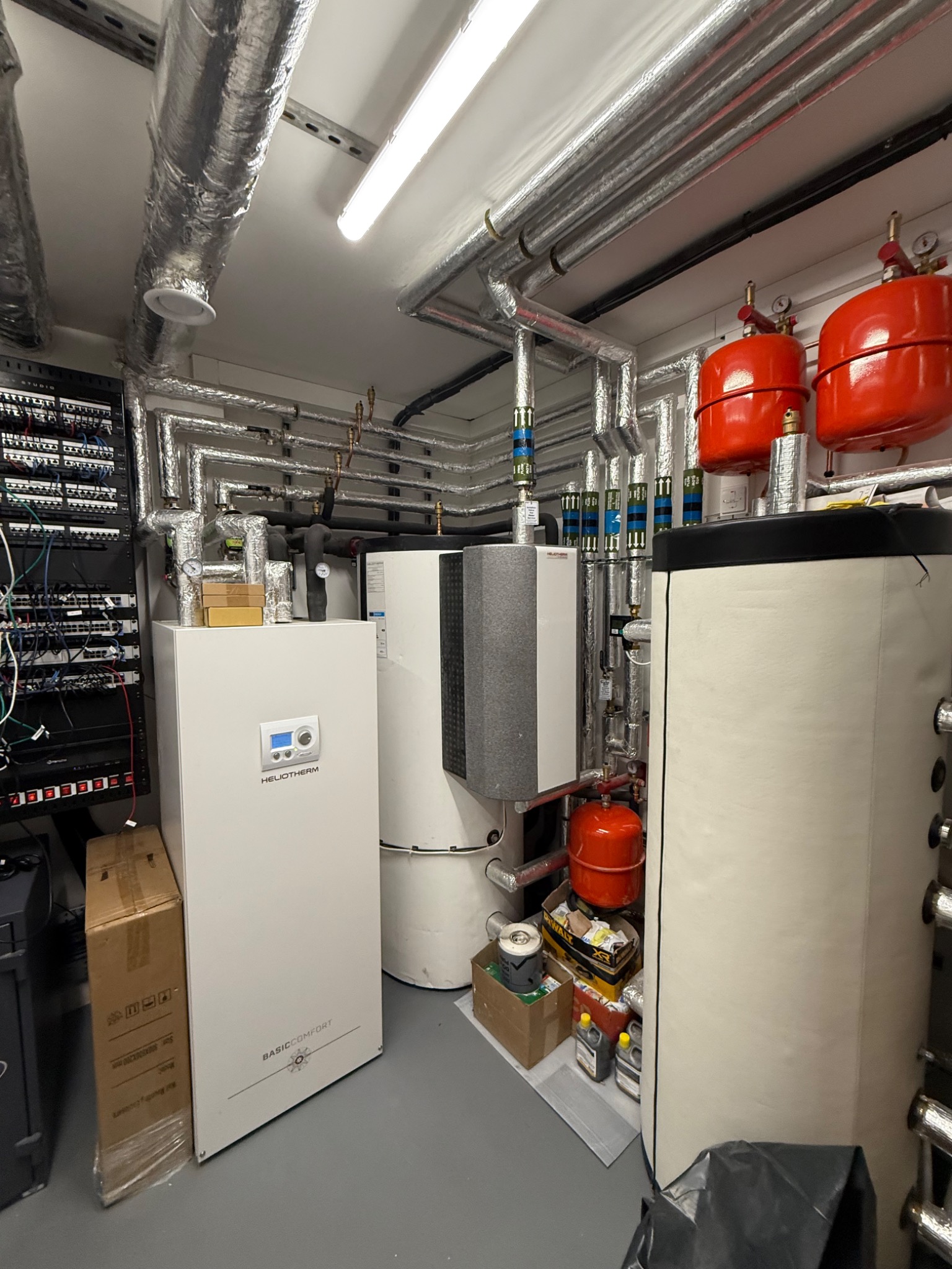 Heliotherm ground source heat pump plant with thermal storage, expansion vessels and labelled circuits.
