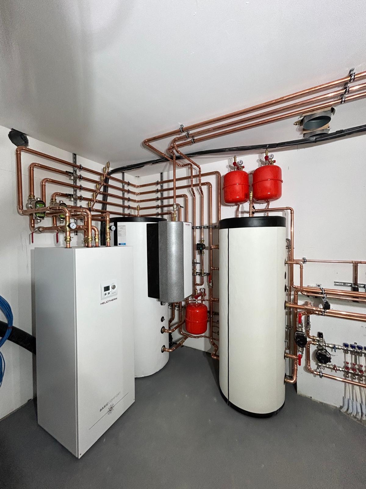 Heliotherm ground source heat pump installation with neatly coordinated copper distribution pipework.