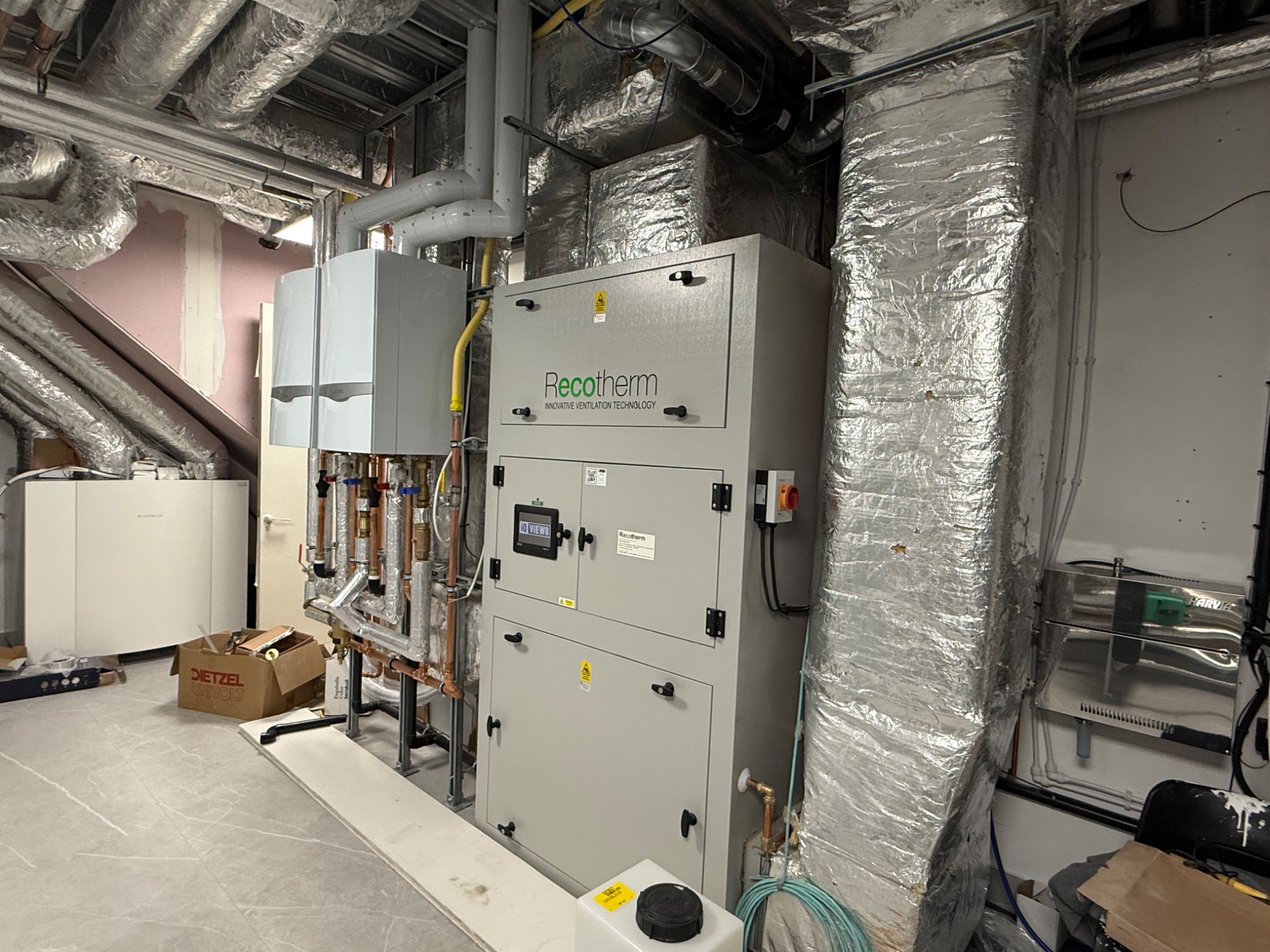 Solux swimming pool plant room installation — air handling unit with insulated ductwork and boiler plant