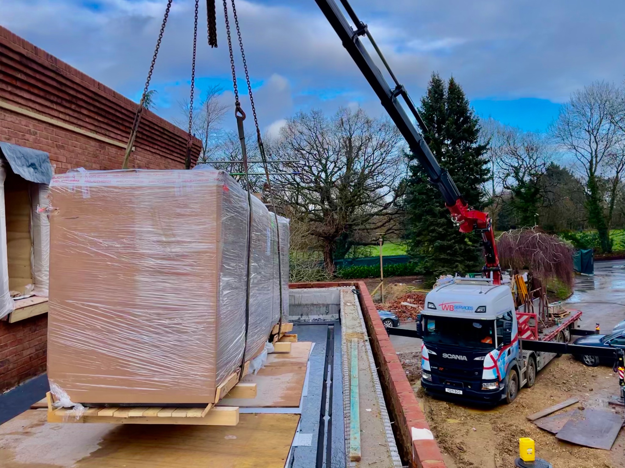 Large heat pump units being craned into position during construction.