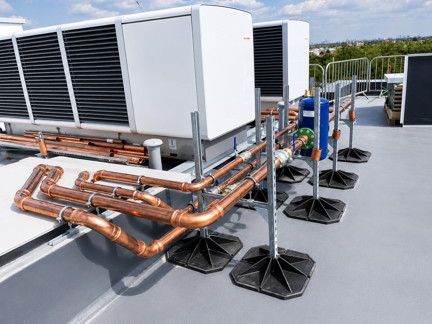 Multi-unit rooftop heat pump arrangement with supported copper headers.