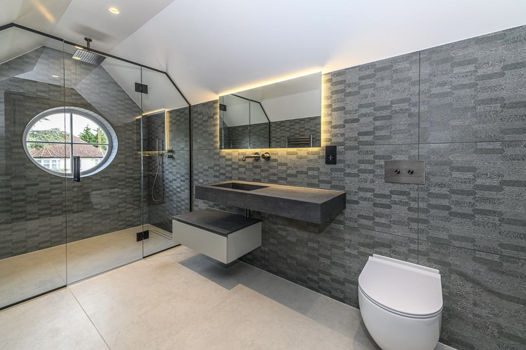 Loft shower room with textured stone tiling and concealed lighting