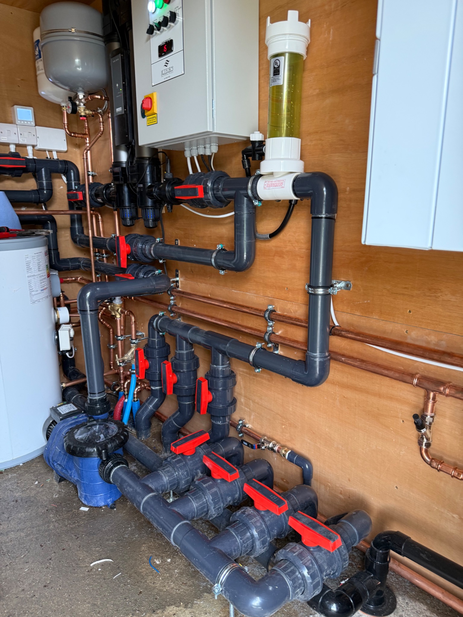 Solux swimming pool plant room installation — PVC filtration manifold, UV treatment and control panel