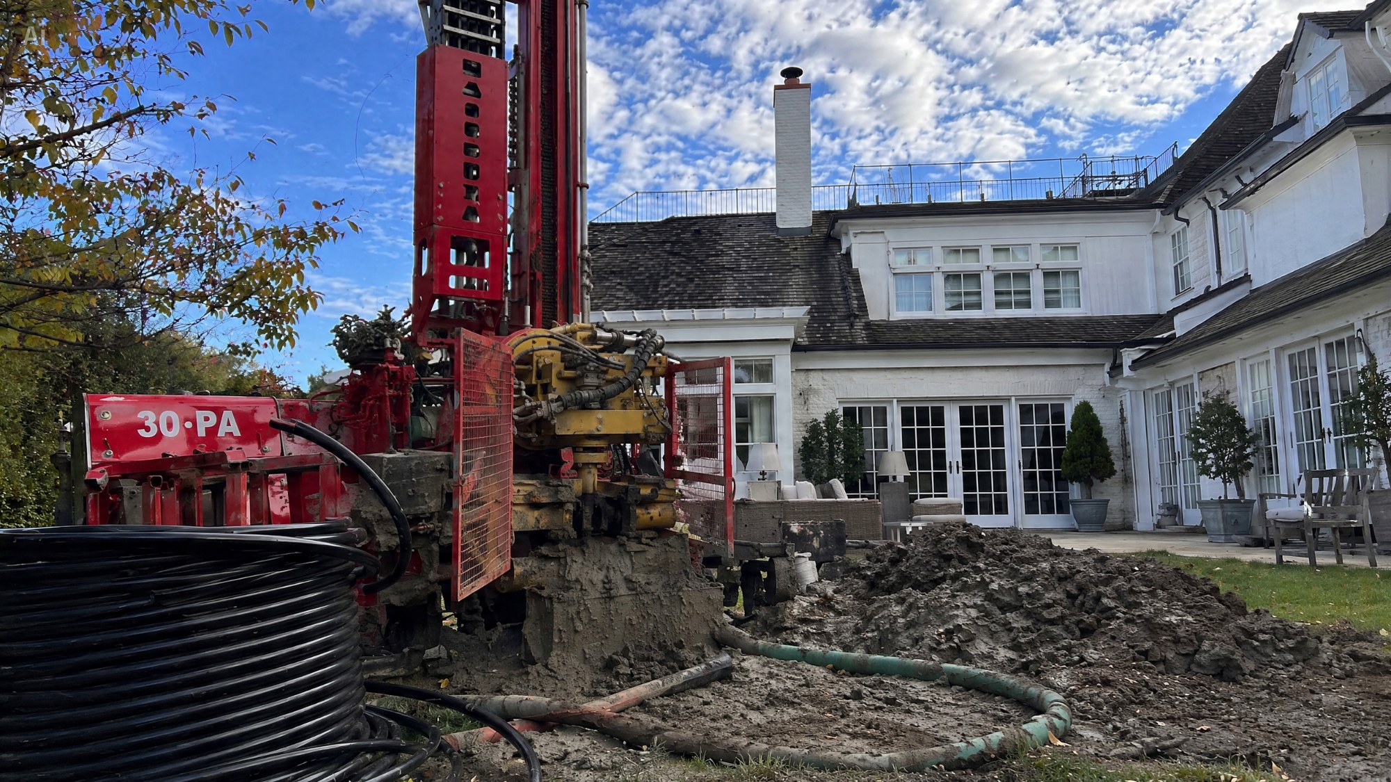 Borehole drilling rig with coiled ground-loop pipe prepared for installation