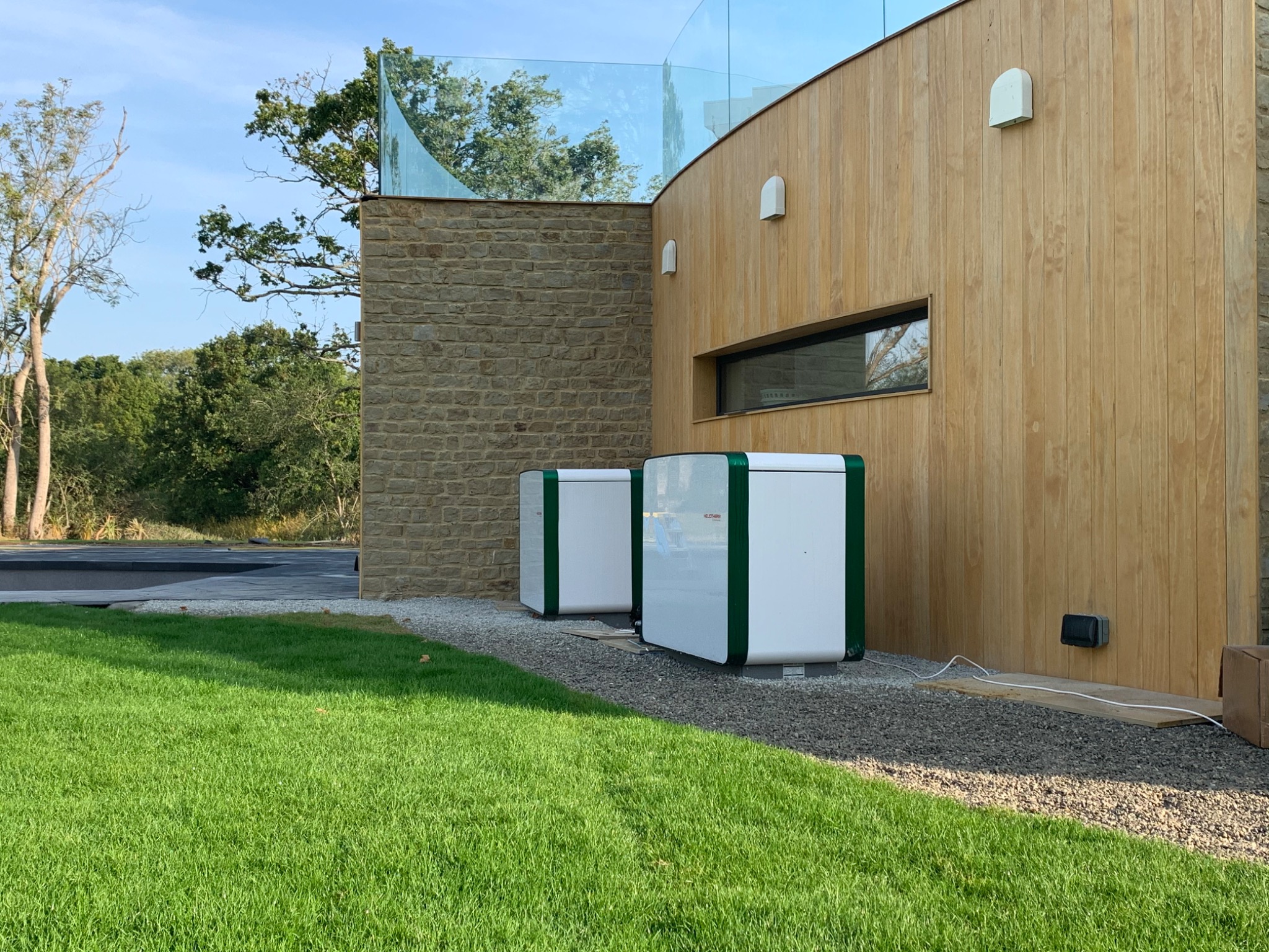 Pair of Heliotherm heat pump units positioned beside a contemporary property.