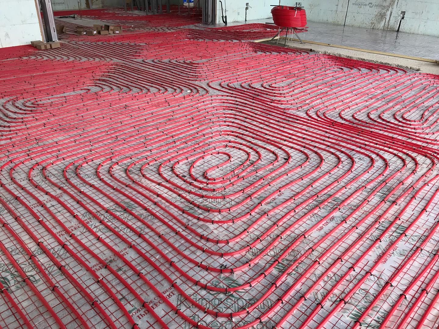Large floor area covered with red underfloor heating pipe loops