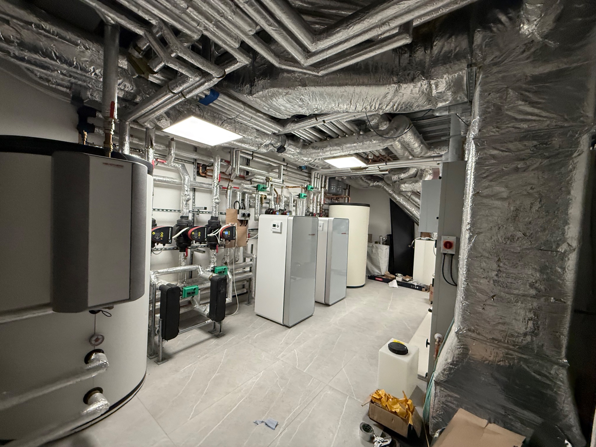 Plant room with pump sets, cylinders and insulated ceiling pipework
