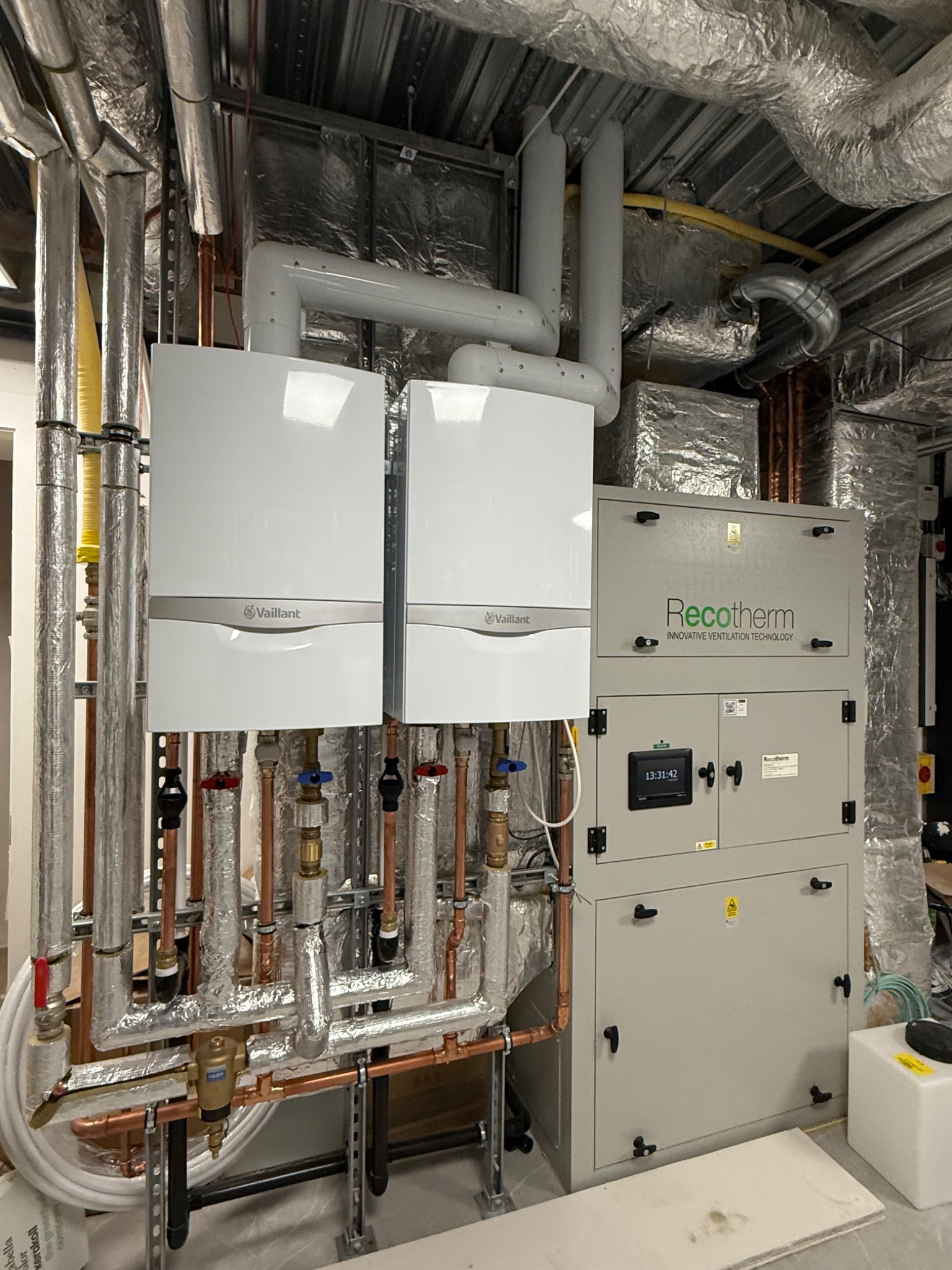 Solux swimming pool plant room installation — twin boilers alongside pool hall air handling unit