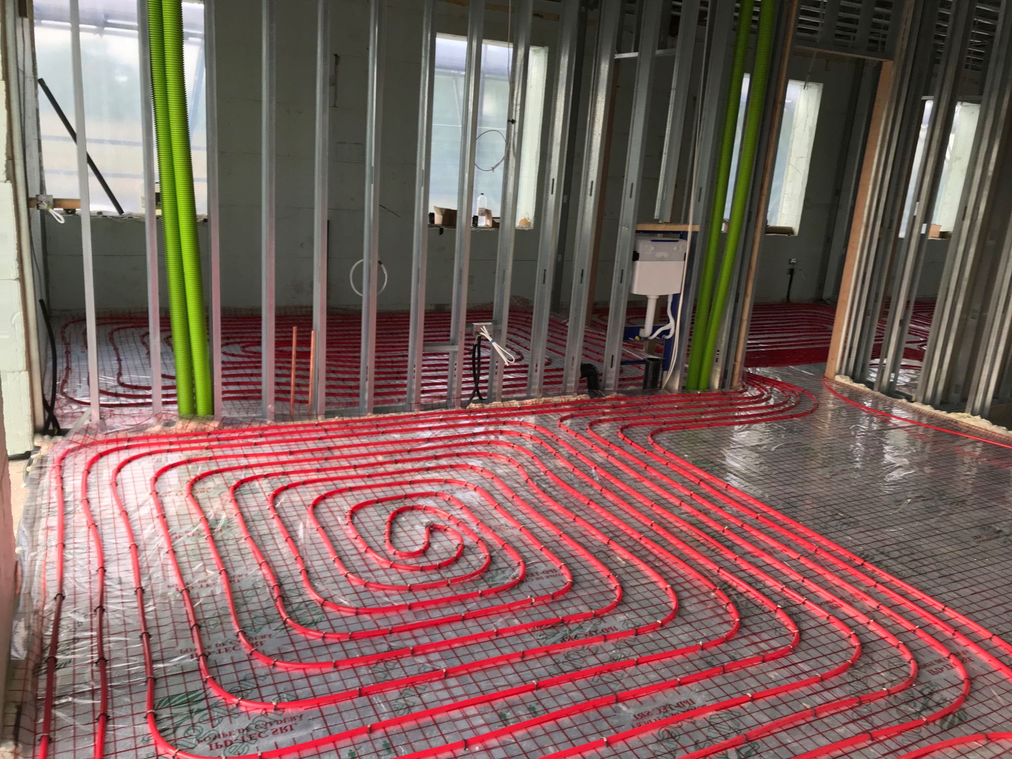 Spiral underfloor heating coil in a room with metal stud partitions